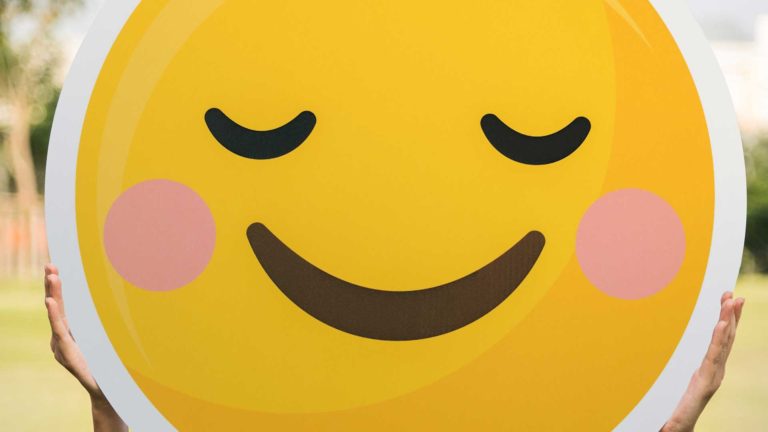 Person holding big happy emoticon