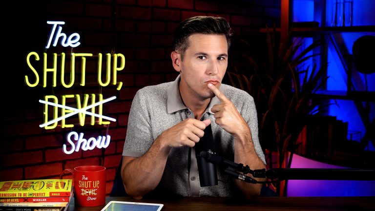 Kyle Winkler at desk, serious expression with finger over mouth